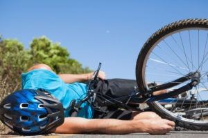 bicycle accident victim lying on the pavement 300x200 1