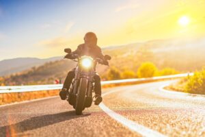 Man on a motorcycle riding on a road, highlighting the risk of car drivers failing to spot motorcycles.