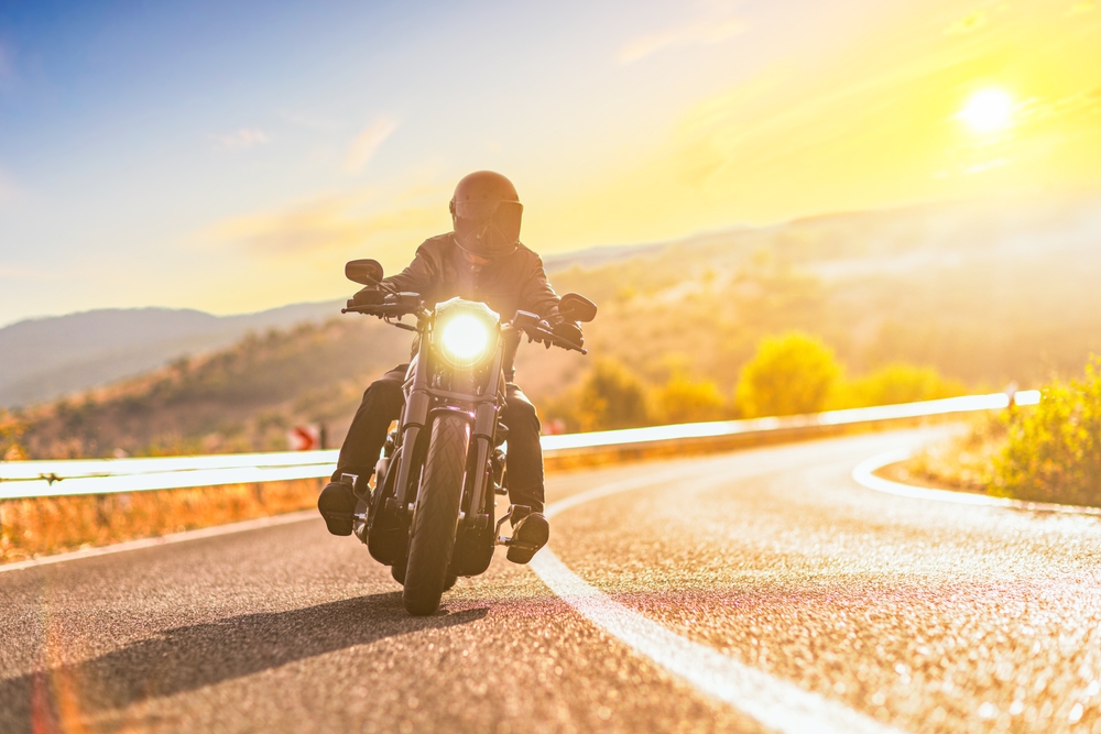 Man on a motorcycle riding on a road, highlighting the risk of car drivers failing to spot motorcycles.